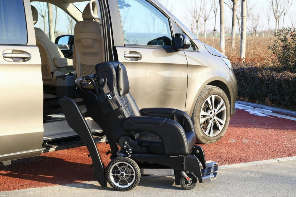 Accessible transportation van with its sliding door open and a wheelchair set next to it.