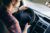 An over-the-shoulder view of a driver wearing a plaid shirt.